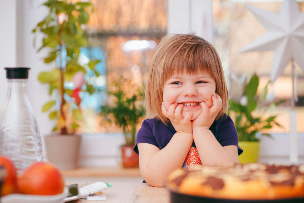 Smiling child sitting at table with cake