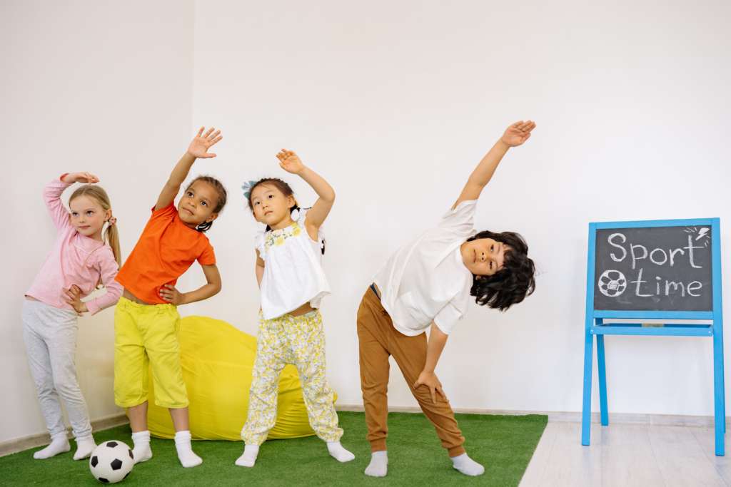 Children stretching indoors during sport time